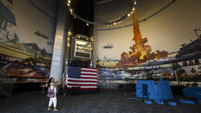 Sheila Pickett takes a photo of Robert McCall's 360-degree mural at the Arizona Challenger Space Center in Peoria. The center closed Aug. 5.