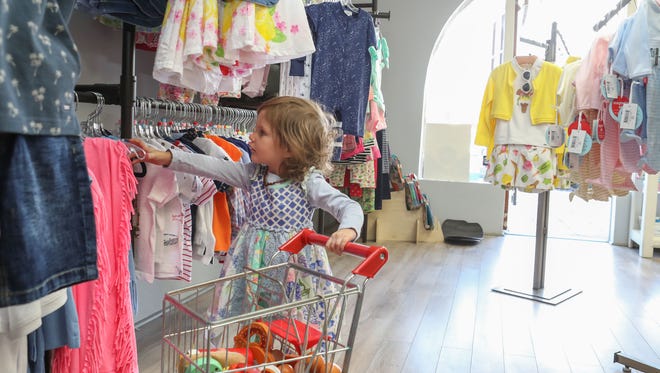 Two-year-old Caroline McDaniel looks at clothes at JadaBug's Kids Boutique in La Quinta, February 23, 2018.