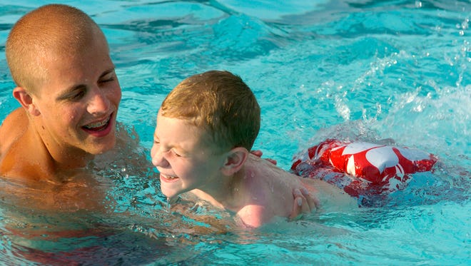 File photo: Lifeguard-swim instructor holds on as he teaches Elijah Price, 6 years-old, to kick Monday during the second session of swim lessons held at Atkinson Park Pool. (Gleaner photo by Mike Lawrence ¥ 831-8346 or mlawrence@thegleaner.com) 06/26/2006