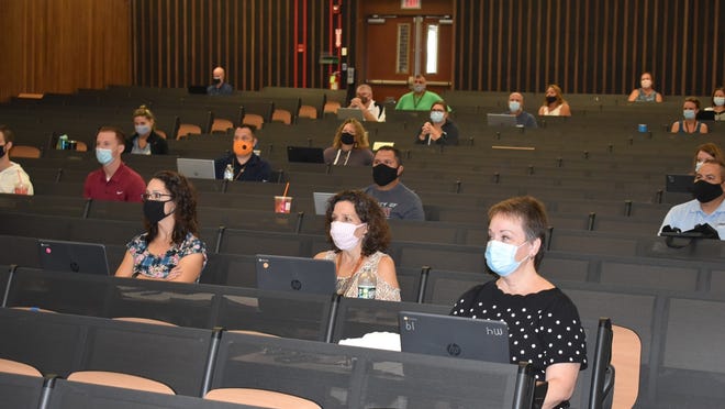 Diman Regional Vocational Technical High School teachers sit socially distanced in the auditorium at the school in this file photo. Gov. Charlie Baker and the state's largest teachers' unions are butting heads over the unions' request to allow teachers to be vaccinated in schools.