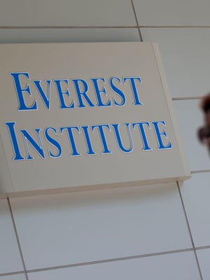 File photo shows a passerby near an Everest Institute sign in Silver Spring, Md. Everest is one of several for-profit higher education programs run by Corinthian Colleges.