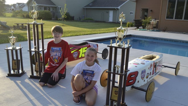 Cousins Peyton Van Gruensven, left, of Menasha, and Brooklyn Van Gruensven, of Suamico, pose with their cars and the trophies they earned in the prestigious All-American Soap Box Derby in Akron, Ohio.