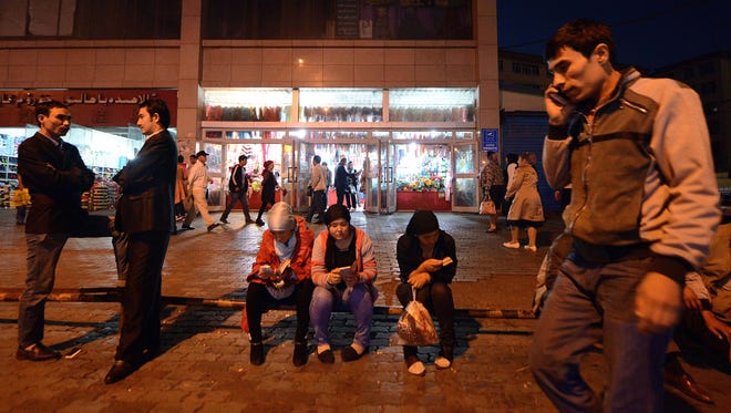 This picture taken on September 17, 2014 shows young Uighurs resting near the Grand Bazaar in Urumqi, farwest China's Xinjiang region.  Xinjiang, home to some 10 million of China's Muslim Uighur minority, with its vast mineral wealth and billions of dollars of investment, analysts say much of the proceeds have flowed to Han Chinese, stoking resentment amongst many Uighurs.