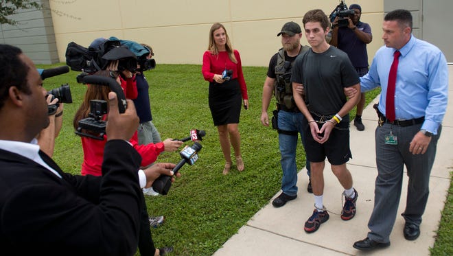 Austin Harrouff, 19, (center) is surrounded by South Florida media during his booking process into the Martin County Jail at the Martin County Sheriff's Office in Stuart on Oct. 3, 2016. Harrouff was charged with two counts of first-degree murder, attempted murder, resisting an officer without violence and burglary of a dwelling while armed, according to Sheriff William Snyder, in the deaths of a Martin County couple. Harrouff was found on top of the male victim, biting off pieces of his face and abdomen.