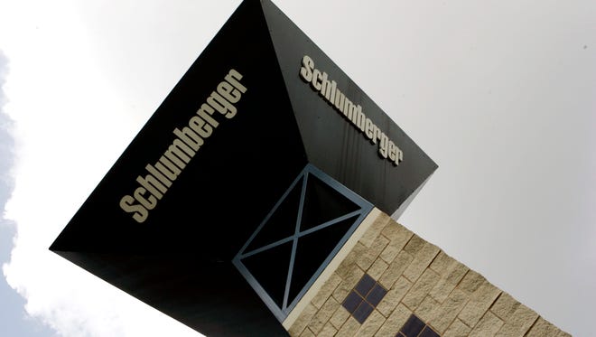 A sign tower reaches toward the sky at the entrance to Schlumberger Ltd.'s campus in Sugar Land, Texas. Schlumberger has cut another 10,000 jobs, according to reports.