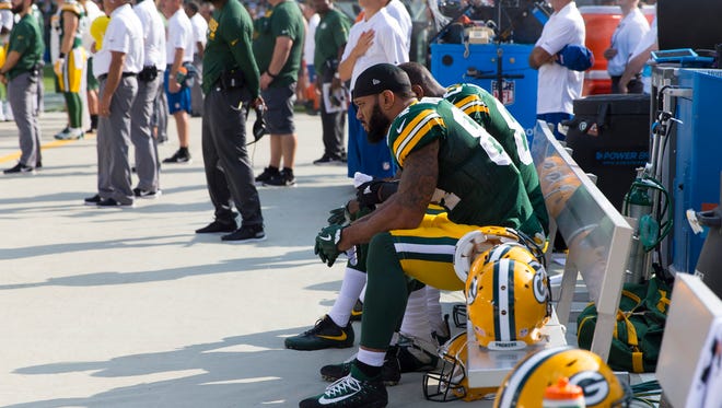 Green Bay Packers tight end Lance Kendricks (84) and tight end Martellus Bennett (80) sit on the bench during the national anthem prior to the game against the Cincinnati Bengals at Lambeau Field.