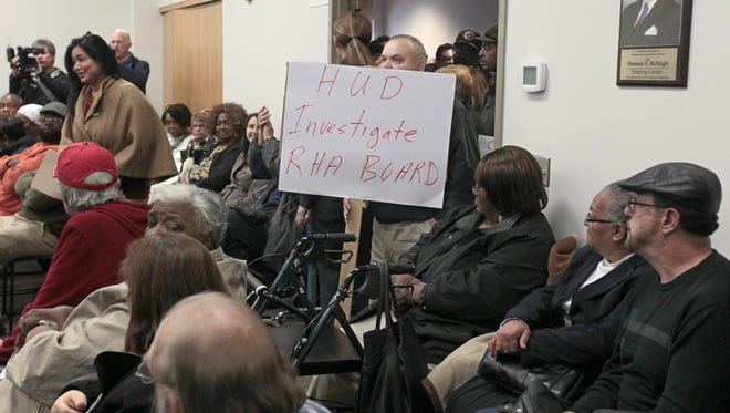Albert Algaran, Rochester, holds up a sign asking for a HUD investigation at the Rochester Housing Authority board meeting.