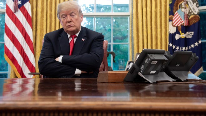 President Donald Trump sits at the Resolute Desk during a briefing on Hurricane Michael in the Oval Office of the White House in Washington, D.C., on October 10, 2018.