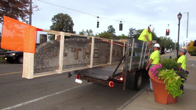 A crew from Streeter Associates secures the sign from the former Grand Theater in Elmira to a moving truck Wednesday morning.