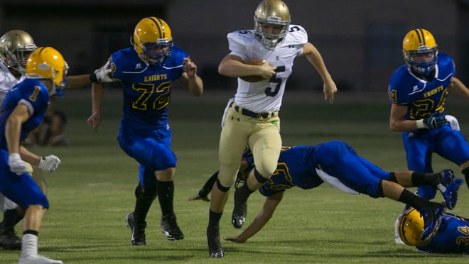 Yuma Catholic's Jagan Cleary breaks away from a tackle attempted by Tempe Prep's Zachariah Brittain at Phoenix Arizona Lutheran on Aug. 29. Yuma Catholic won the game 56-27 and meet Saturday for the Division V state championship at Phoenix North Canyon.