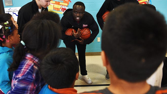 Roosevelt High School boys basketball player Manny Christopher introduces himself to a group of Jane Addams Elementary School students during a visit to the school Wednesday, March 16, 2016, in Sioux Falls.