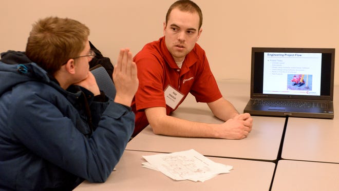 Guest speaker Matt Holschuh, engineer at Manitowoc Cranes, right, explains his job duties as part of the crane design team at an informational classroom breakout session focused on careers in science, technology, engineering and mathematics during the Career Expo at Lakeshore Technical College Cleveland Campus on Friday. Sue Pischke/HTR Media. Photo taken on Friday, Jan. 9, 2015.
