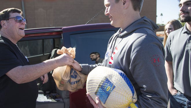 Williams Haber (left) donates a turkey to United Food Bank volunteer Matt Erickson on Nov. 22, 2016.