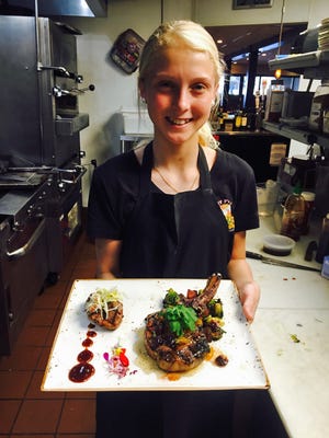 Taylor Sanders showcases her pork medallions with Asian barbecue sauce, cabbage slaw and grilled pork chops with bacon in the kitchen of Jimmy P's Charred. Chef Chris DeGenova helped her prepare for the Food Network's "Kids BBQ Championship," set to air at 8 p.m. Monday.