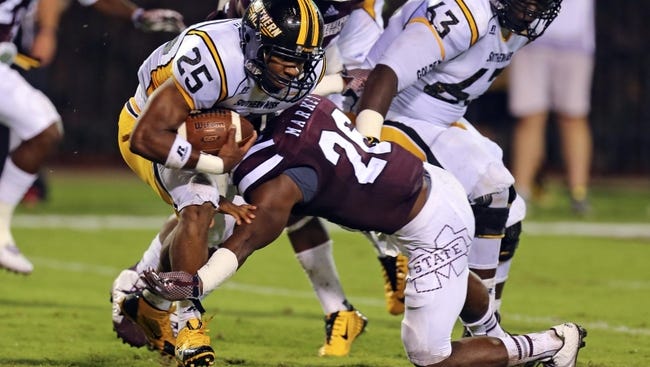 Aug 30, 2014; Starkville, MS, USA; Southern Miss Golden Eagles running back George Payne (24) runs the ball and is tackled by Mississippi State Bulldogs defensive back Kendrick Market (26) during the game at Davis Wade Stadium.  Mississippi State Bulldogs defeat the Southern Miss Golden Eagles 49-0. Mandatory Credit: Spruce Derden-USA TODAY Sports