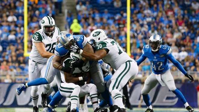 Detroit Lions defensive tackle Jermelle Cudjo (63) tackles New York Jets running back Daryl Richardson (35) during an NFL preseason football game at Ford Field in Detroit, Thursday, Aug. 13, 2015.