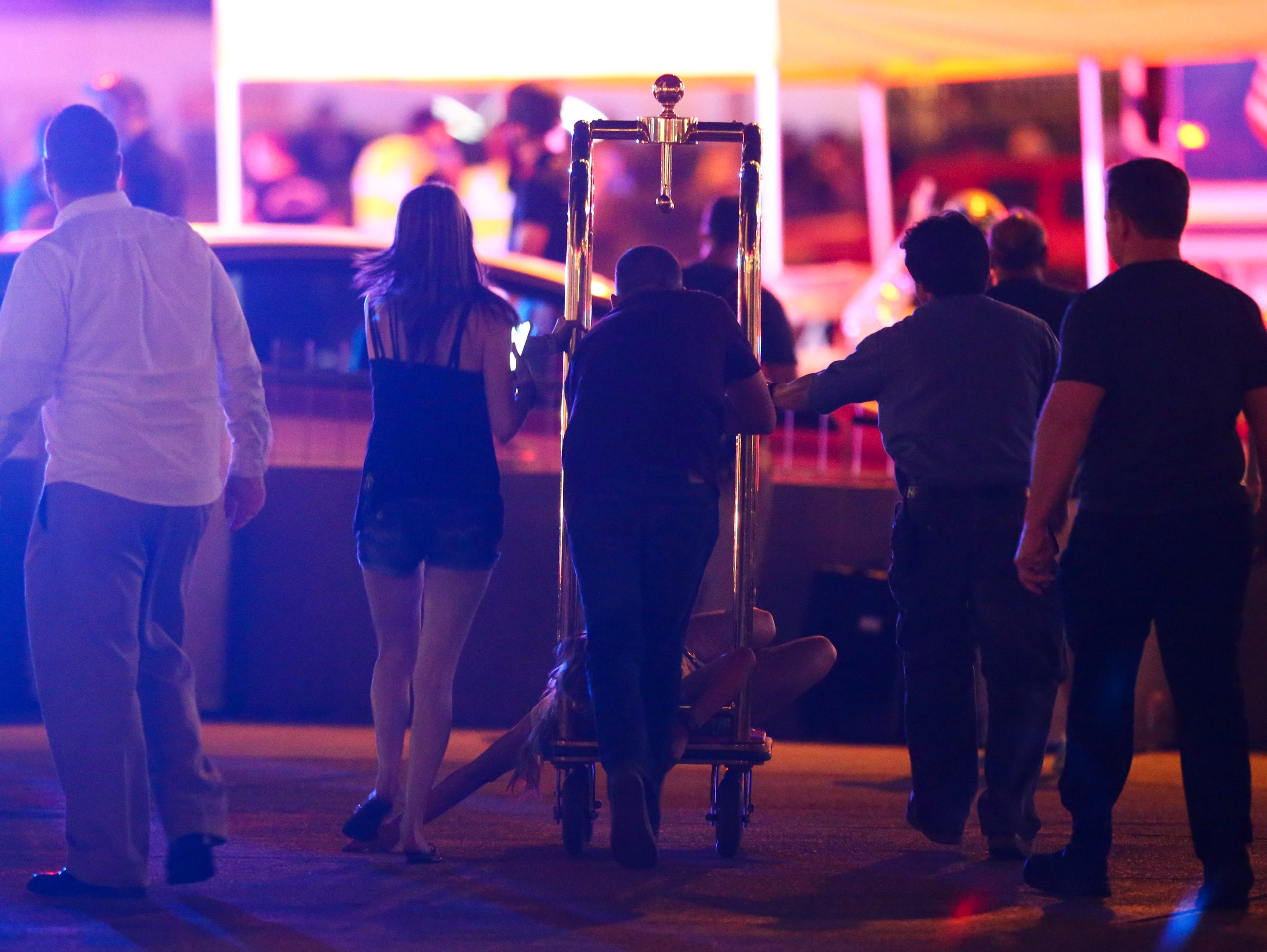 A wounded woman is moved outside the Tropicana on a hotel baggage cart during an active shooter situation on the Las Vegas Strip.