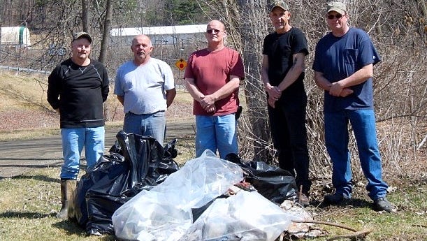 Volunteers from the Riverside Patriots show off trash they collected from the Chemung River Fitch's Bridge boat launch in Big Flats.