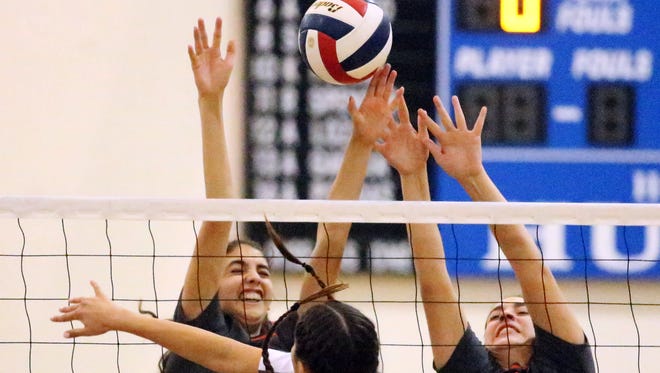 Vivien Marquez, 5, of Chapin attempts to get the ball over the outstretched hands of Emily Perez, left, and Italia Gonzalez of El Paso High Tuesday night at Chapin. 
