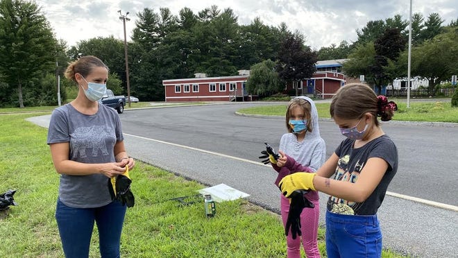 Lisa Sigmon and her daughters Ellison and Emory gloved up to prepare for the clean up at the Dutile Elementary School