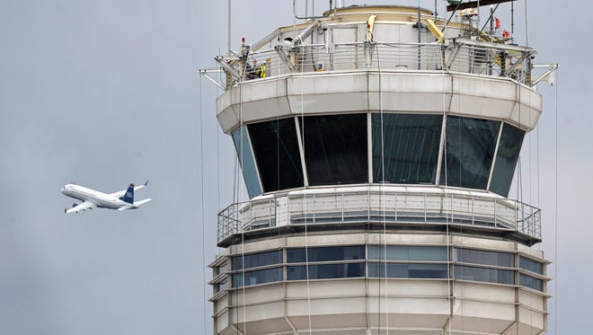 A passenger jet flies past the FAA control tower at Washington's Ronald Reagan National Airport. Air traffic control systems are one possible target of cyber terrorists, experts say.
