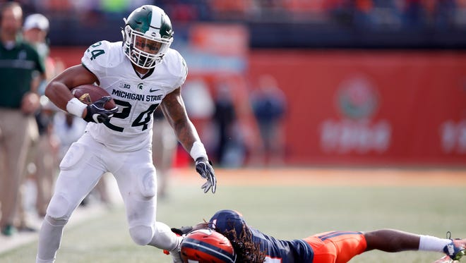 Michigan State running back Gerald Holmes (24) tries to break free from Illinois defensive back Jaylen Dunlap on Saturday, Nov. 5, 2016, in Champaign, Ill.
