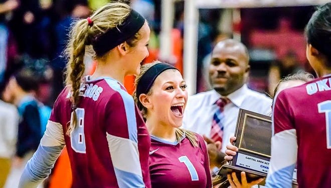 Brooke Bez ,1, of Okemos celebrates after she and her teammates were awarded the CAAC Blue chanpionship trophy after the win over Holt Tuesday  in Okemos.