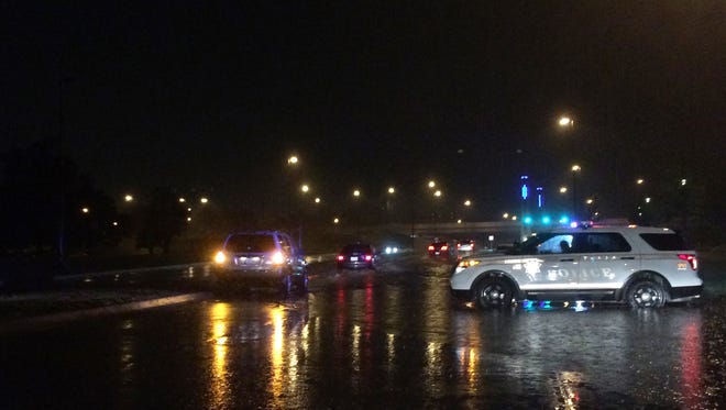 Tulsa police block Riverside Drive  because of flooding over the road due to torrential rains on Friday, May 8, 2015 in Tulsa, Oka. The National Weather Service says there's a risk of severe thunderstorms Saturday, including possible tornadoes and large hail,  in parts of western Kansas, western Colorado, and the Oklahoma and Texas panhandles.