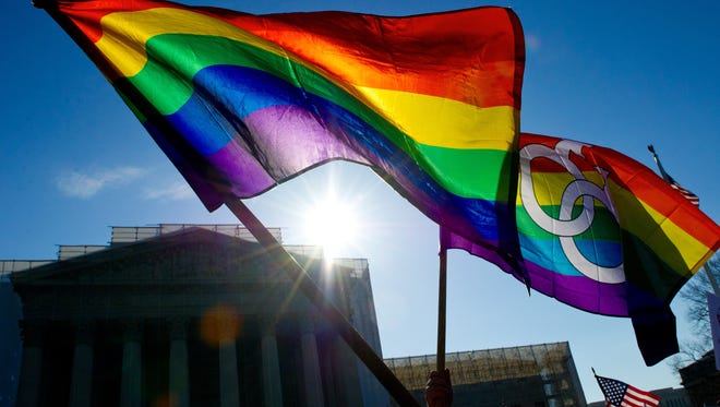 In this March 27, 2013, file photo, gay pride flags fly at the Supreme Court in Washington.