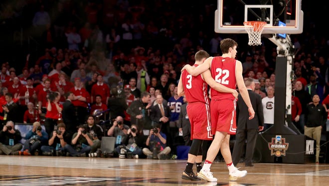 Ethan Happ (left) and Zak Showalter of the Wisconsin Badgers walk off the court after being defeated by the Florida Gators in overtime, 84-83, in the 2017 NCAA Tournament East Regional at Madison Square Garden.