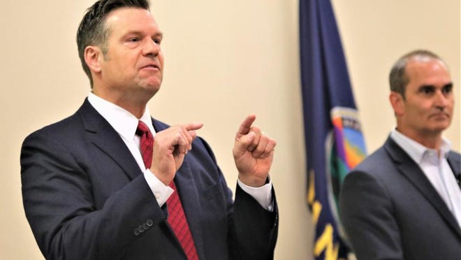 Republican candidate for U.S. Senate Kris Kobach speaks at a debate earlier this year with rival Bob Hamilton looking on.