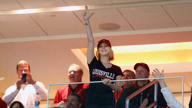 Actress Jennifer Lawrence, a Louisville native and Cardinals fan, throws up the "L" hand sign during the NCAA college basketball game between in-state rivals Louisville and Kentucky on Saturday, Dec. 27, 2014, in Louisville, Ky.