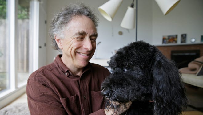 Michael Fasman poses with his dog Hudson at his home in San Francisco.