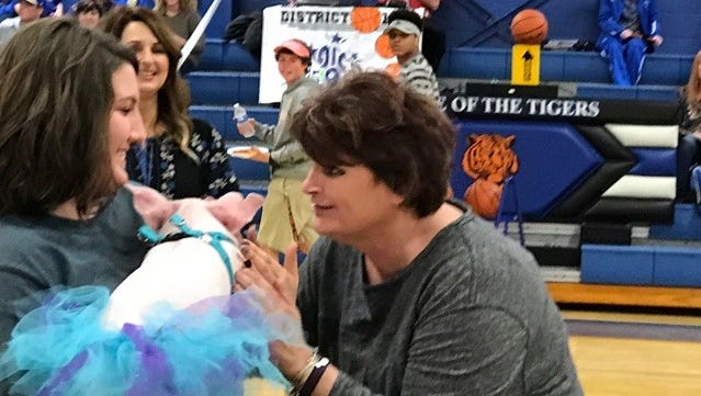Bruceton Central Beta Club sponsor Theresa Scott prepares to kiss a pig Tuesday night when the Tigers played Huntingdon.