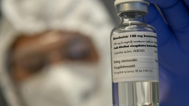 A bottle containing the drug Remdesivir is held by a health worker in October at the Institute of Infectology of Kenezy Gyula Teaching Hospital of the University of Debrecen in Debrecen, Hungary.