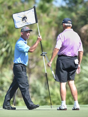 Professional Golfer Corey Pavin (left), holds the hole marker on the second green for golfer John Blake, of Vero Beach, during the Kenny Perry Invitational, Monday, Feb. 12, 2018, at the Bent Pine Golf Club in Vero Beach. "I'm just glad to be here to help Kenny (Perry) out," Pavin said. "Kenny has been a friend for a long time, an I've said on tour we all have charities that are near and dear to us, and just glad to help out a friend like Kenny."