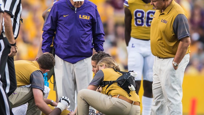 Tigers head coach Les Miles looks in on offensive lineman Jakori Savage (65) after he gets hurt during the first half of a SEC game between Mississippi State and the LSU Tigers in Death Valley on Saturday September 17, 2016.