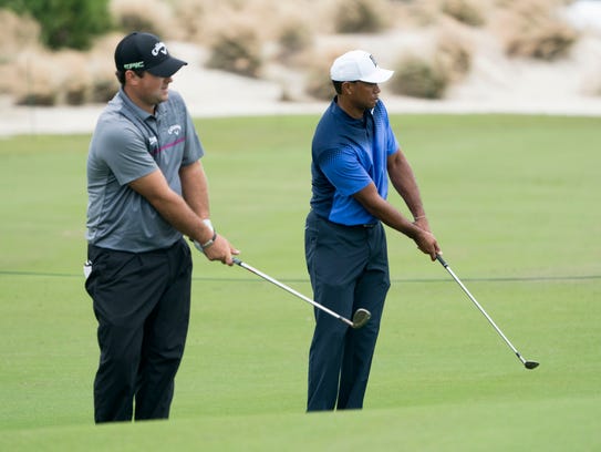   Tiger Woods (right) and Patrick Reed (left) practice 