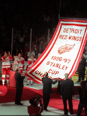 As the 1996-97 Stanley Cup banner is raised to the roof, three Red Wings captains, from left, Brendan Shanahan, Nicklas Lidstrom and Steve Yzerman cheer during pregame ceremonies at Joe Louis Arena on Oct. 8, 1997.