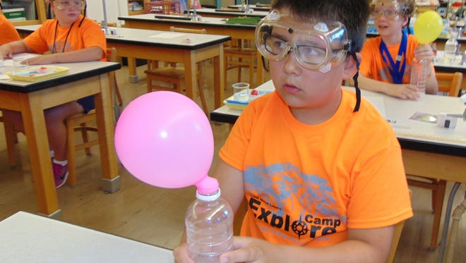 Students participate in a science experiment using balloons and water bottles during last year’s session of Camp Explore at Silver Lake College. This year’s camp will run July 25-29.