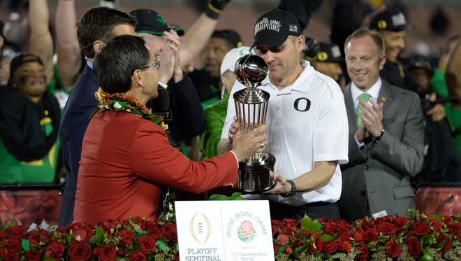 Jan 1, 2015; Pasadena, CA, USA; Tournament of Roses president Rich Chinen and ESPN announcer Rece Davis present the Leishman Trophy to Oregon Ducks head coach Mark Helfrich after the Oregon Ducks defeated the Florida State Seminoles in the 2015 Rose Bowl college football game at Rose Bowl. Mandatory Credit: Kelvin Kuo-USA TODAY Sports