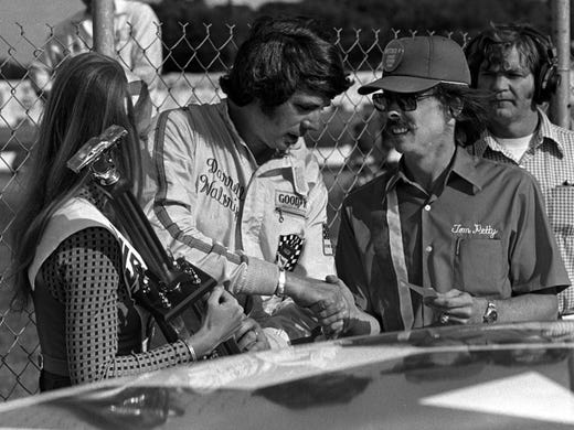 Darrell Waltrip, middle, receives a check from Tom