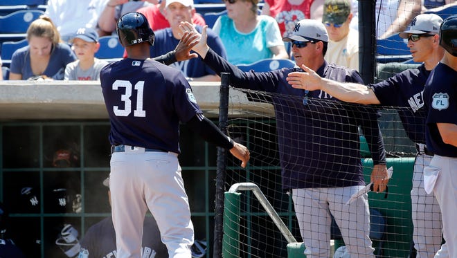 Yankees bench coach Rob Thomson, here congratulating Aaron Hicks during spring training, is managing the Yankees on Friday night with Joe Girardi, far right in this photo, attending his daughter's graduation.