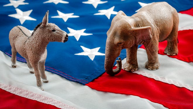 A Democrat donkey and Republican elephant squaring off atop the American flag.