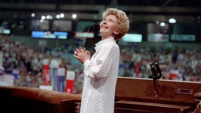 Nancy Reagan looks at President Ronald Reagan on the screen behind her at the Republican National Convention in Dallas on Aug. 22, 1984.