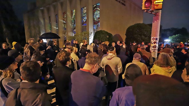 A group gathers outside the Tree of Life Synagogue for a vigil to honor the victims of the Saturday attack on a synagogue in California, Saturday, April 27, 2019, in the Squirrel Hill neighborhood of Pittsburgh. It is six months to the day that a gunman shot and killed 11 people while they worshipped at the Tree of Life Synagogue on Oct. 27, 2018. (AP Photo/Gene J. Puskar)