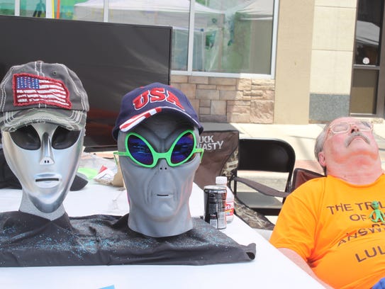 Patrons visit with outdoor vendors sporting Alien-theme