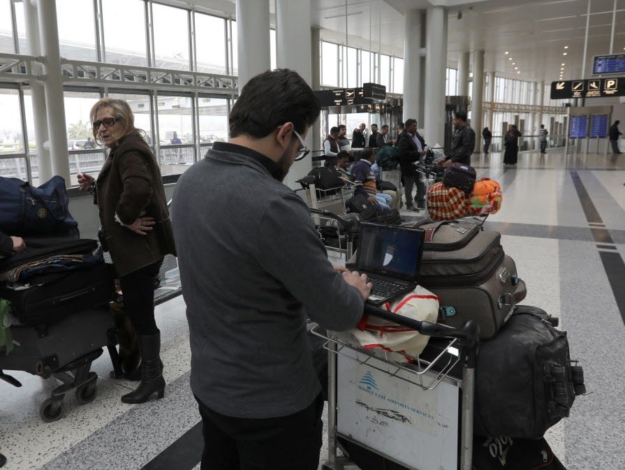A Syrian passenger traveling to the United States through Amman, Jordan, types on his laptop before entering Beirut International Airport's departure lounge in Lebanon on March 22, 2017.