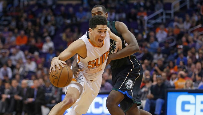 Devin Booker (1) drives past the Bucks' Khris Middleton (22) in the second half at Talking Stick Arena on Dec. 20, 2015 in Phoenix, Ariz.