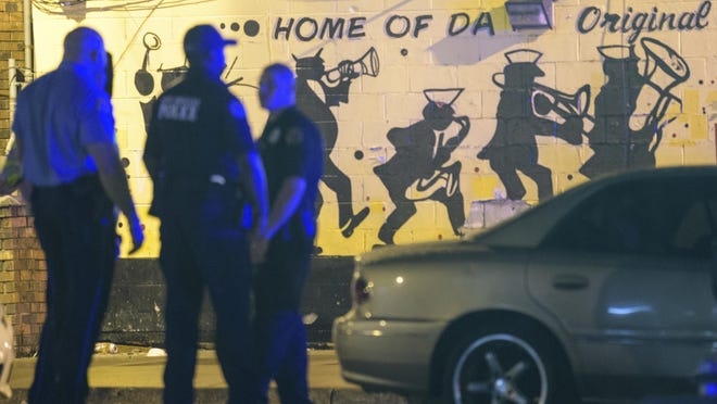 New Orleans Police Department investigators work near the scene of a shooting in New Orleans, Saturday night, July 28, 2018. Two armed individuals walked up to a crowd gathered outside a strip mall in New Orleans and opened fire, killing three people and wounding seven more, the police chief said. (Matthew Hinton/ via AP)